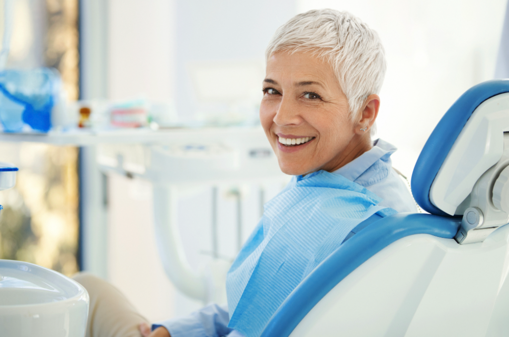 A female sits in the dentist’s chair and smiles